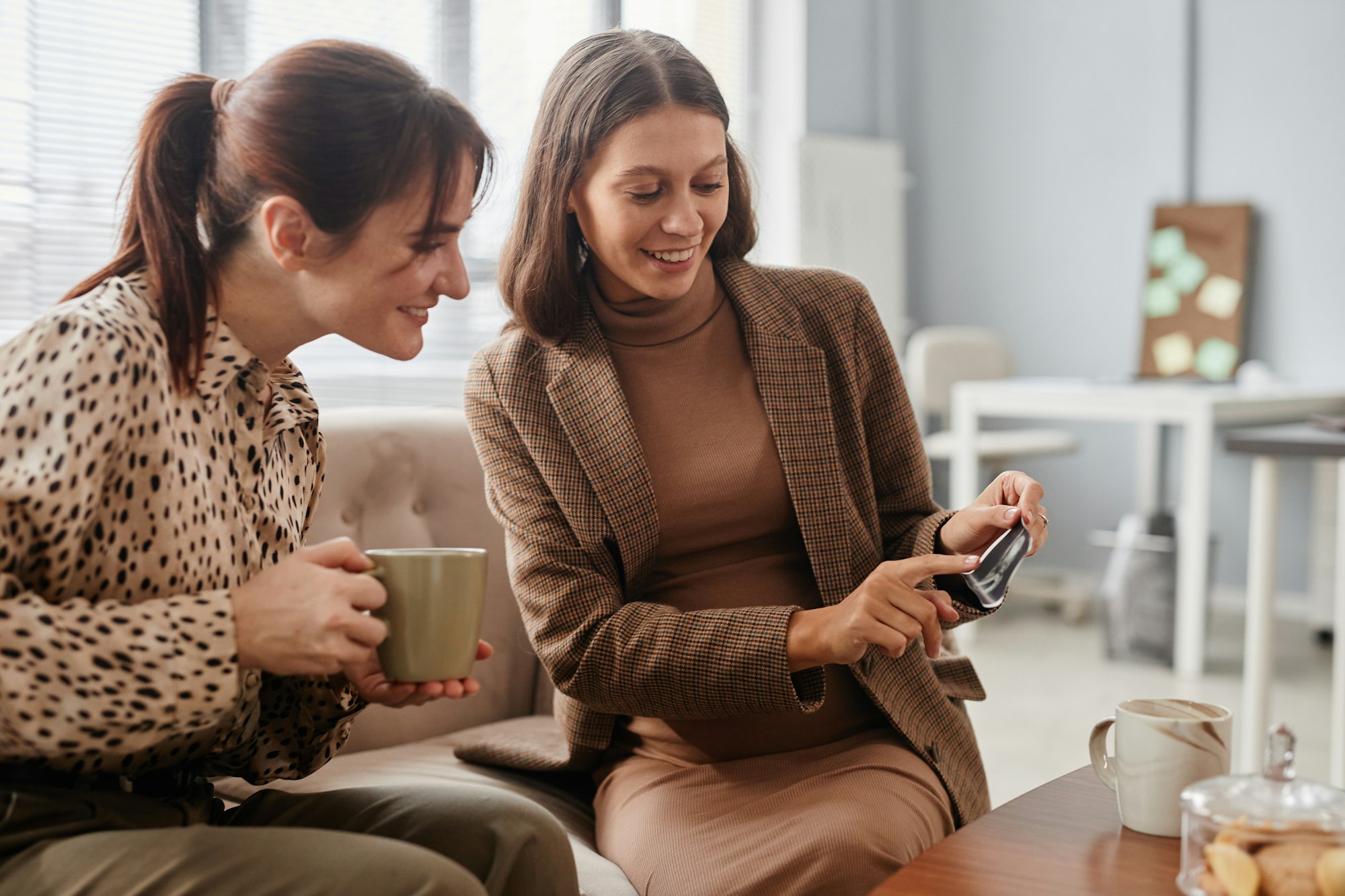 Friends talking during coffee break at office